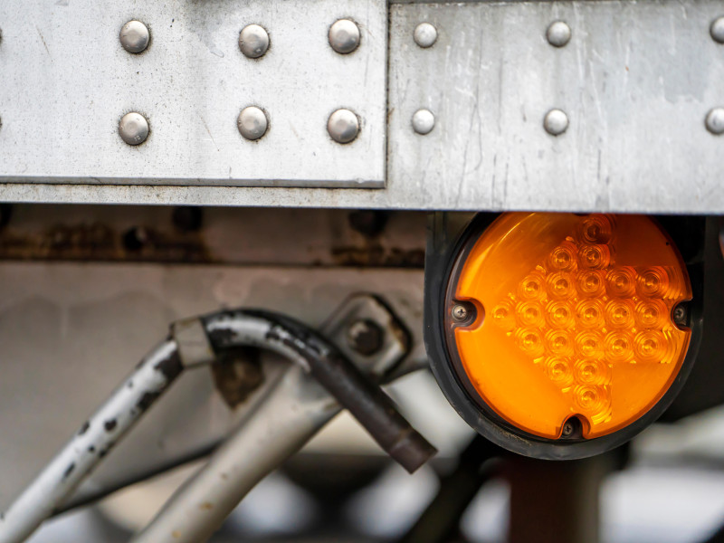 Las luces marcadoras redondas de color naranja señalan con una flecha de encendido en el lateral del semirremolque grande de aluminio.